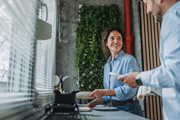 Couple washing dishes together during daily routine