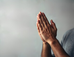 Person clasps hands together in prayer. Man shows gesture of worship, spiritual devotion. Human praying for hope, blessing, guidance. Concept of faith, gratitude, peace, reflection. Religious