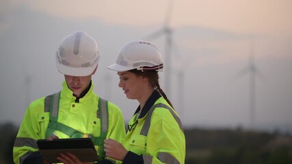 Engineers working and using tablet on site in wind turbine farm, Wind turbines generate clean energy source, Eco technology for electric, industry environment - Powered by Adobe