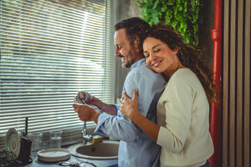 Happy couple bonding doing kitchen chores together