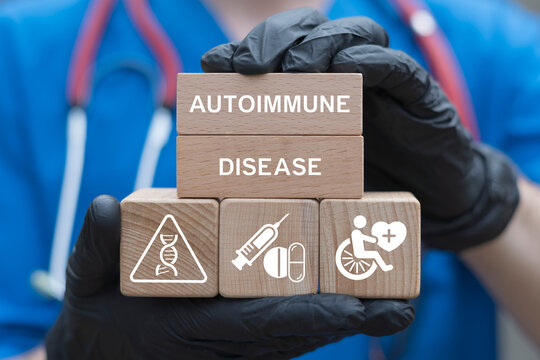 Doctor holding wooden blocks with icons sees the inscription AUTOIMMUNE DISEASE. Autoimmune Disease Health Care Innovation Research concept.