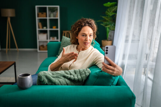Mature woman enjoying coffee while making a video call