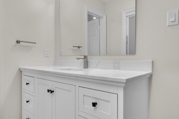 A bright, clean, contemporary bathroom with a white vanity and chrome fixtures.