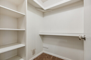 A completely empty walkin closet featuring shelves and a door