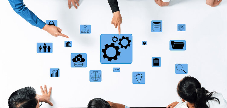 Aerial view of a team collaborating on project planning, utilizing technology icons on a table to enhance communication and streamline business strategies effectively. Trope