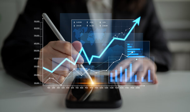A business professional engages in financial analysis using a smartphone and visual digital charts. The scene reflects modern technology role in strategic growth. Scalp