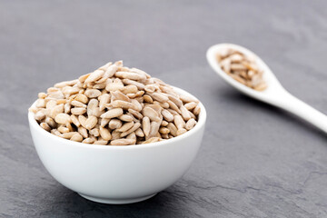 Shelled sunflower seeds in a spoon and bowl - Helianthus annuus