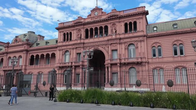 Dynamic hyperlapse of the iconic pink Casa Rosada facade in Buenos Aires, Argentina. Urban life and traffic move quickly around the historic building.