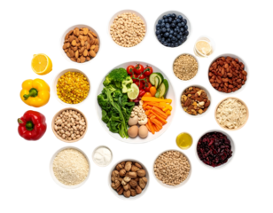 A colorful and diverse assortment of fresh vegetables, nuts, seeds, and dried fruits arranged in bowls around a central plate of raw vegetables