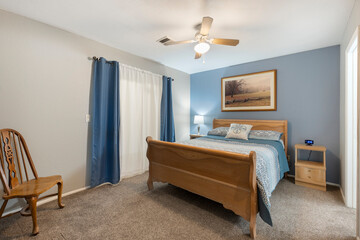 The bedroom features a large bed and is equipped with a ceiling fan