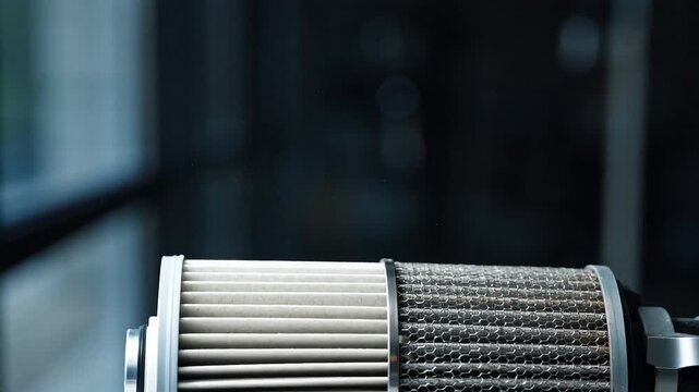 Close-up view of a disassembled engine oil filter, showing the pleated paper and the honeycomb mesh filter element against a dark industrial background