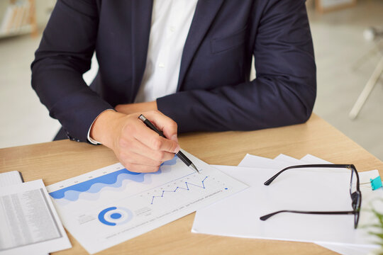 Businessman working with financial documents, graphs, and diagrams in the office. Work focuses on accounting and business inspection, ensuring the accuracy of data for financial decisions and reports.