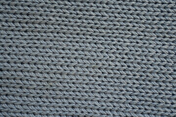 blue macro texture of woolen light gray crocheted sweater as background, close-up of gray crocheted front surface, woolen texture of woolen wool, knitted front surface	
