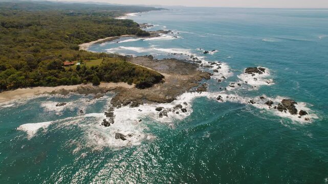 Aerial view of the rocky Costa Rica coastline with turquoise waves on sunny day - Powered by Adobe