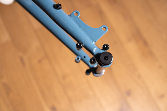 Close up of a bicycle frame rear dropout area showing mounting points of thro axel, bolts, and flat mount brake interface.