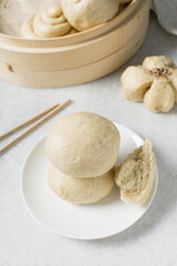 Overhead view of steamed bun on a white countertop, top view of mantou on a white background, process of making steamed milk buns