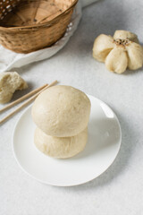 Overhead view of steamed bun on a white countertop, top view of mantou on a white background, process of making steamed milk buns