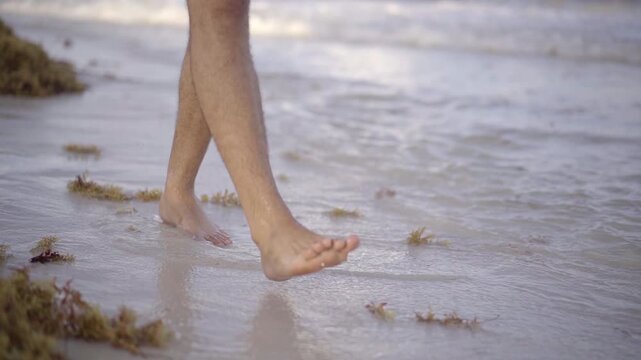 Pies camiando por la playa, arena agua