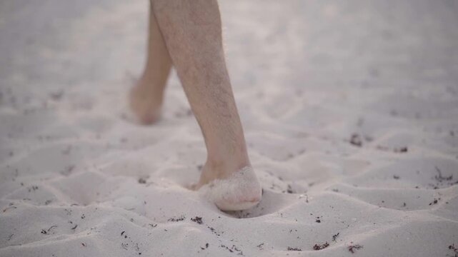 Pies caminando por la arena en la playa 