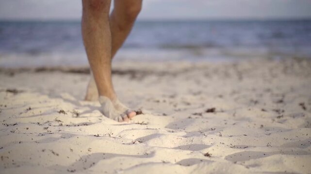 Pies caminando por la arena en la playa 