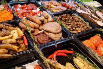 Sausages and frankfurters, fried potatoes, vegetables. Various foods