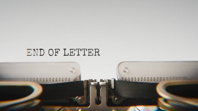 Old mechanical typewriter typing End Of Lettermissing Person File in a close-up view, with metal letters striking the white paper.