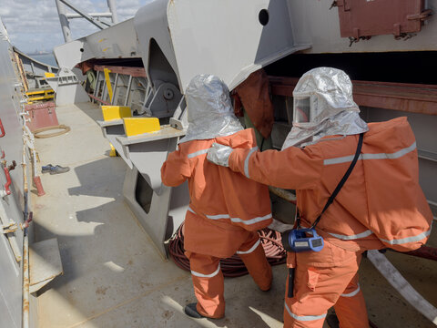 Fire Drill on Cargo Ship Crew Using Firefighting Gear, Breathing Apparatus and Hose During Emergency Training. outside, preparation to entry 1712