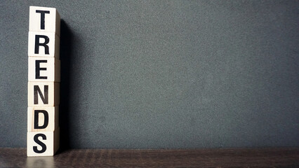 Wooden blocks stacked spelling trends with empty copy space on a dark background.