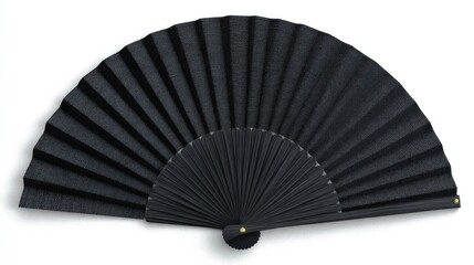 A fully open, textured black folding fan lies on a white surface, casting a soft shadow. The pleats are distinct, and the handle is closed