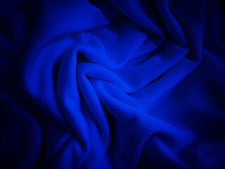 Crumpled dark blue fabric background. Wavy cloth