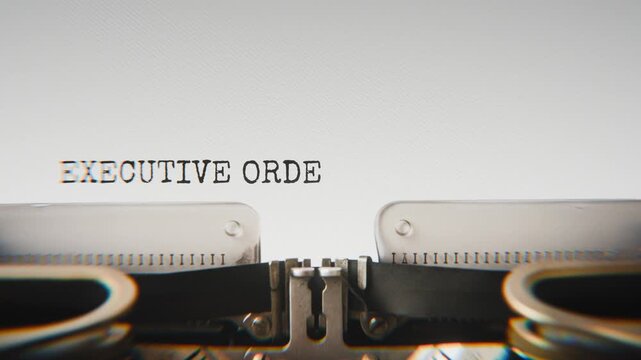 Old mechanical typewriter typing Executive Order 17 in a close-up view, with metal letters striking the white paper.