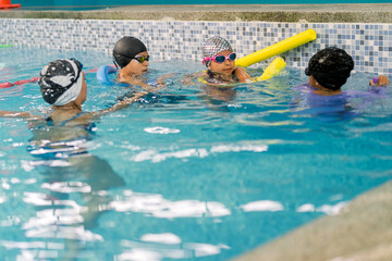 Children learning swimming techniques in a pool class