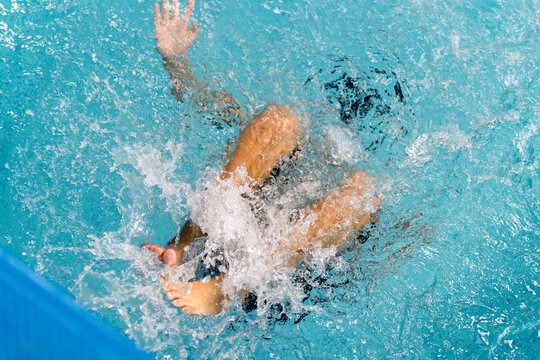 Child learning to swim creating splashing water movement