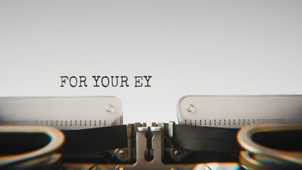 Old mechanical typewriter typing For Your Eyes Only in a close-up view, with metal letters striking the white paper.