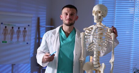 Doctor showing human skeleton model in hospital