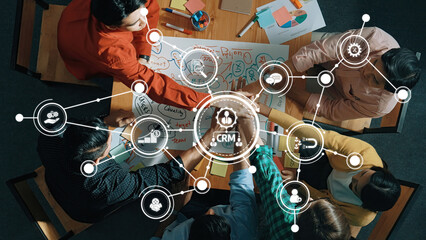 A dynamic team collaborates on CRM strategies using visual planning tools in a modern office setting. Engaged hands and diverse ideas create an interactive environment. Amity