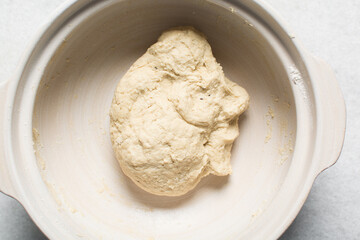 Overhead view of bagel dough being mixed in bowl, top view of homemade bagel dough being mixed in bowl, process of making bagels