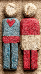 Handmade Textured Paper Couple Figures with Heart on Shirt on Rustic Brown Background