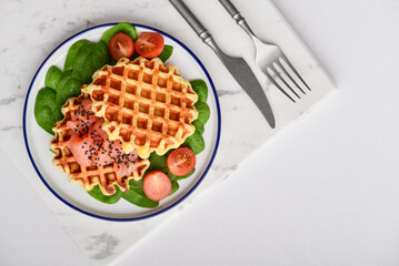 Homemade waffles with lightly salted salmon, spinach and cherry tomatoes