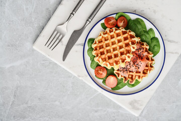Homemade waffles with lightly salted salmon, spinach and cherry tomatoes