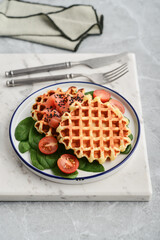 Homemade waffles with lightly salted salmon, spinach and cherry tomatoes