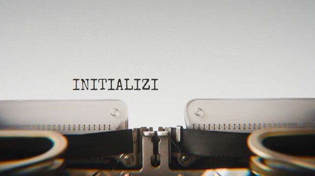 Old mechanical typewriter typing Initializing System in a close-up view, with metal letters striking the white paper.