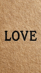 Close-up of Black Embossed Typewritten LOVE Word on Textured Brown Kraft Paper Background