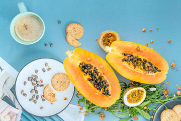Papaya, passion fruit, rucola and granola on a blue background.