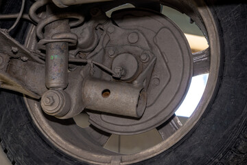 Wear on coil spring shock absorber and twisted axle beam indicates high mileage or rough road use. selective focus