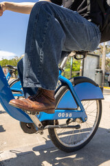 Obraz premium Man riding rental bike in city street