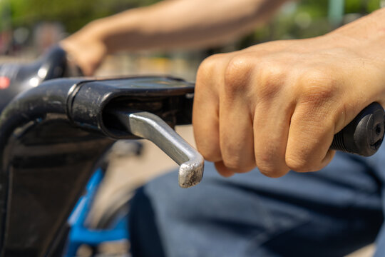 Human hand gripping bicycle handlebar and brake lever
