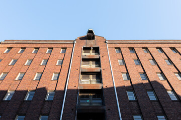 Old industrial building exterior in the HafenCity of Hamburg, Germany. Iron hook lifting mechanism and large doors for every floor of the warehouse. Hoist device for transportation.