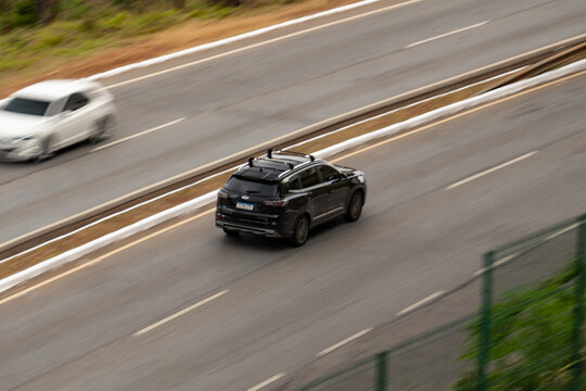 Black Chery Tiggo 8 SUV driving fast on highway panning shot