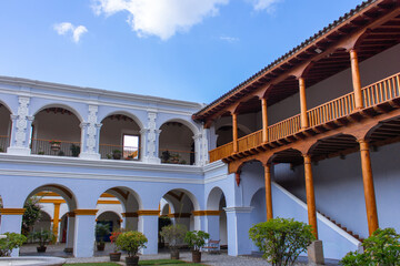 Historic colonial courtyard in Antigua Guatemala elegant white arches warm wooden balconies Spanish style architecture and open sky creating a serene blend of colonial and natural